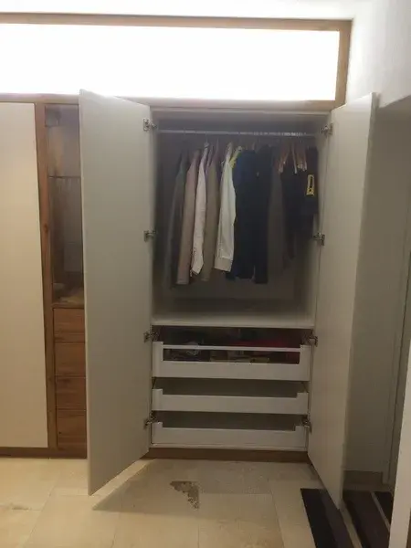 geöffnete Garderobe mit Stange und Schubladen