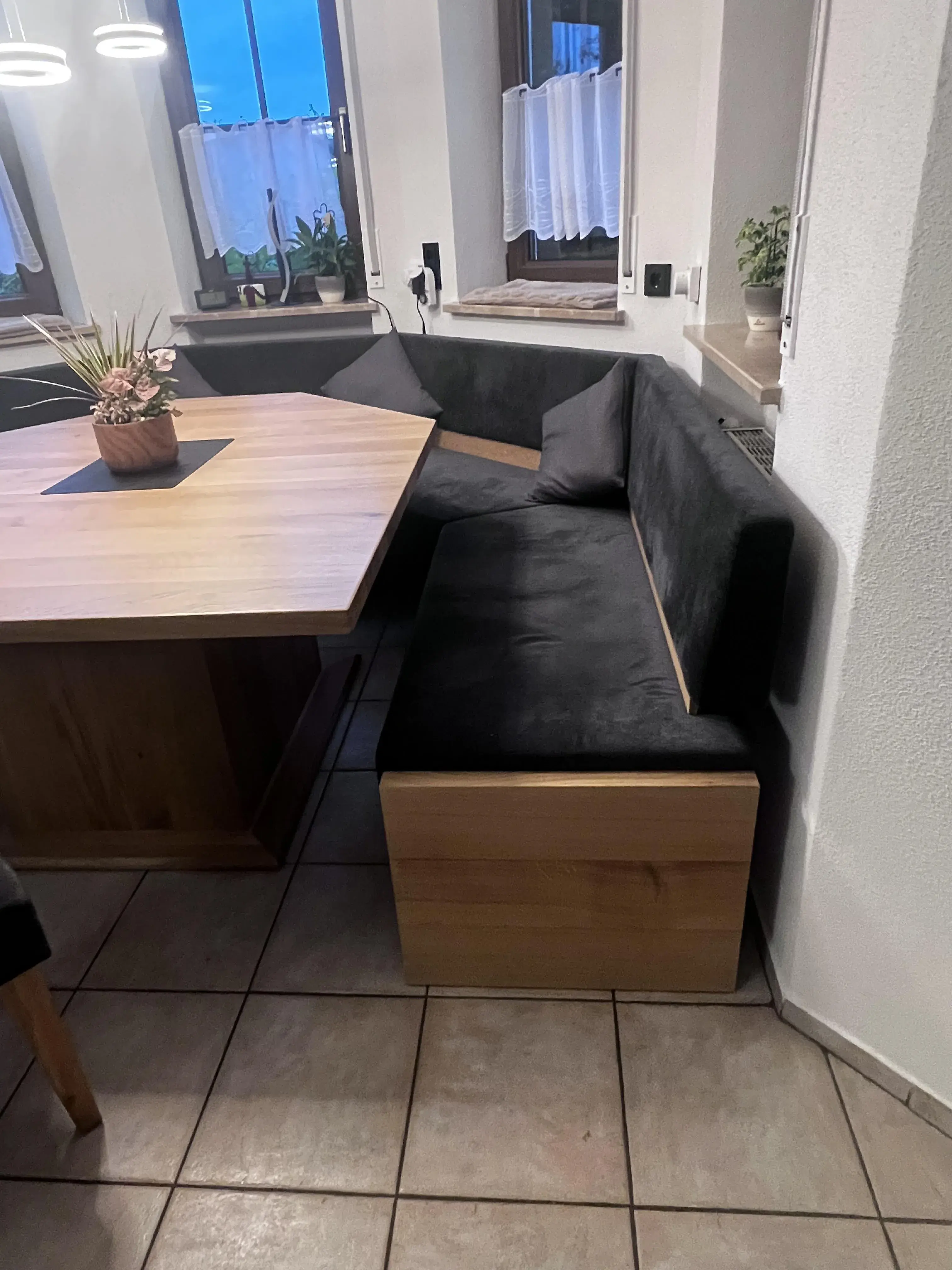 Eckbank mit schwarzem Polster und Holztisch in einer gemütlichen Essecke
