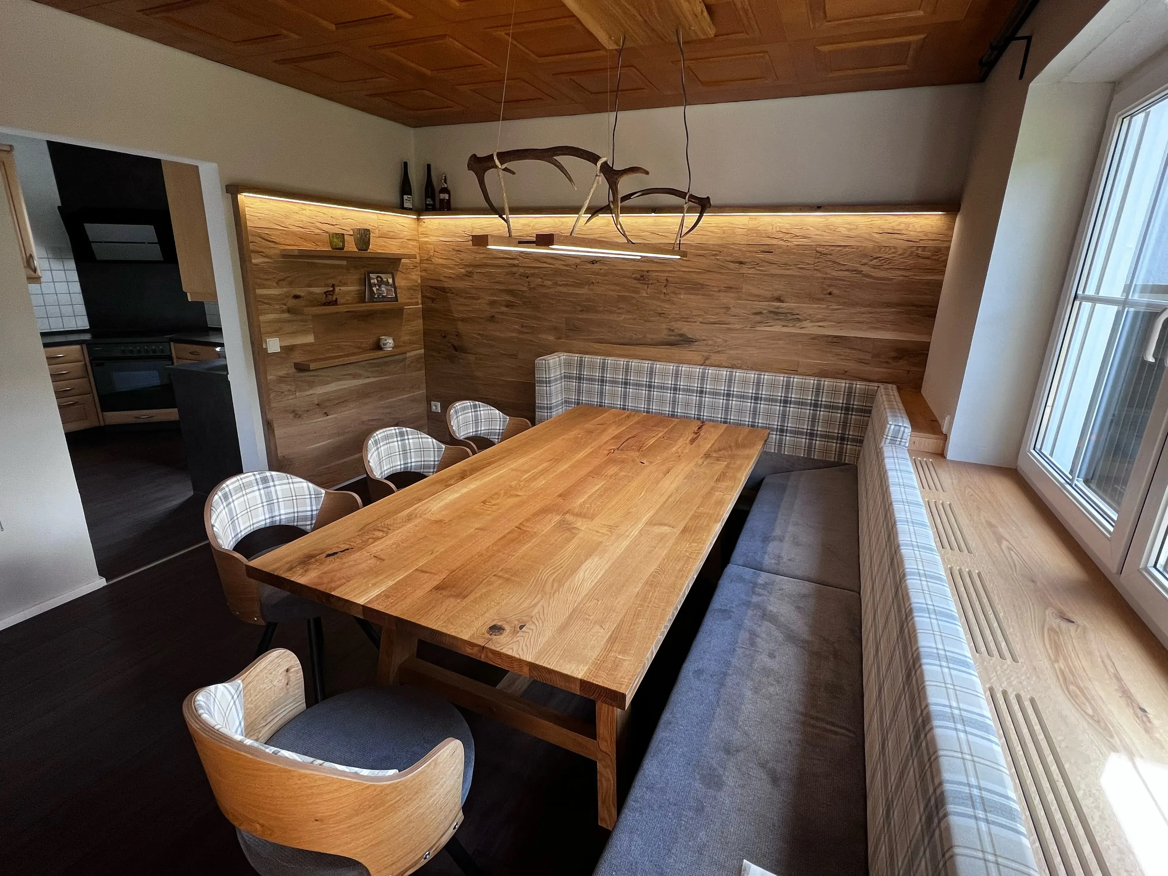 Heller Essbereich mit Holztisch, gepolsterter Eckbank und Stühlen, modernes Ambiente.