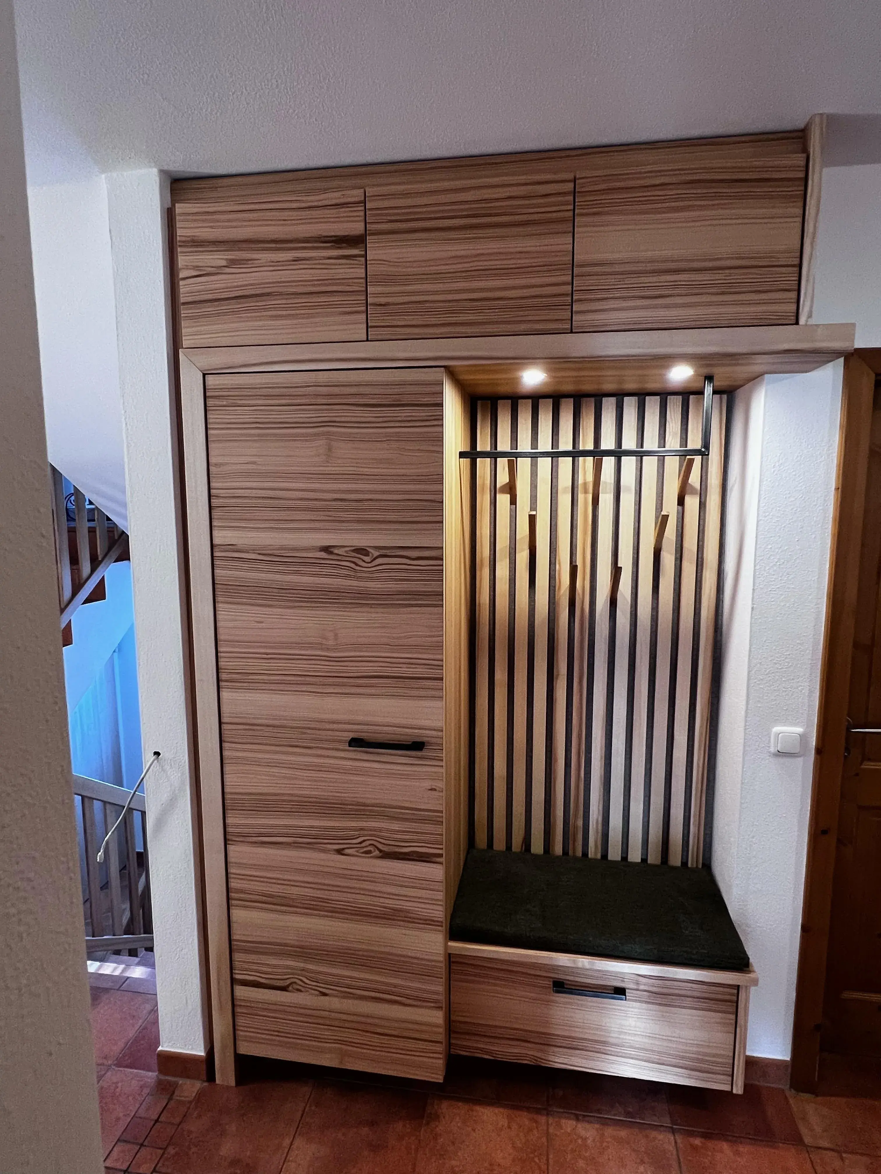 Moderner Flurschrank aus Holz mit offenen Fächern, Haken und LED-Beleuchtung.