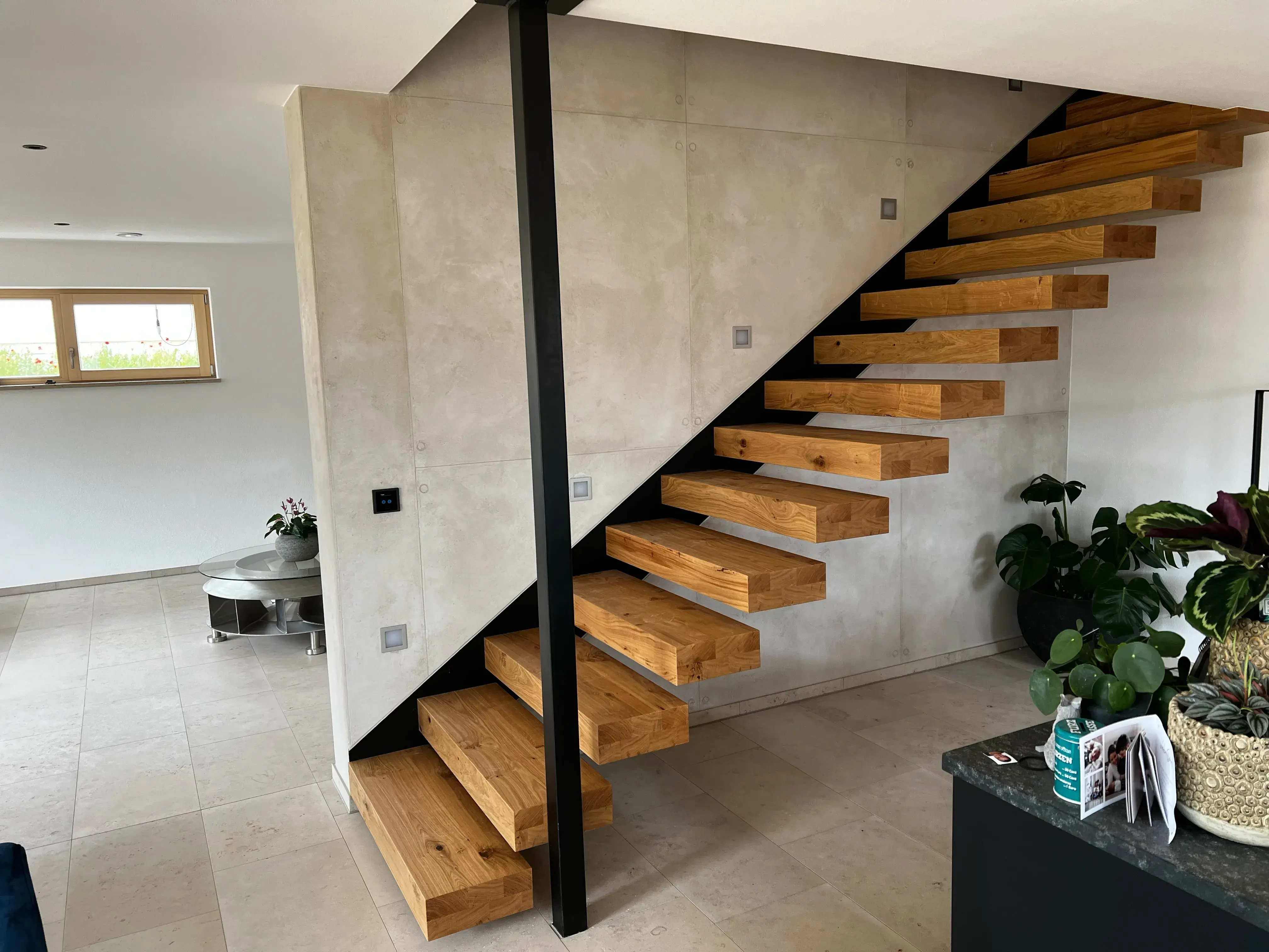 Moderne Holztreppe mit offenen Stufen in einem hellen Wohnzimmer.
