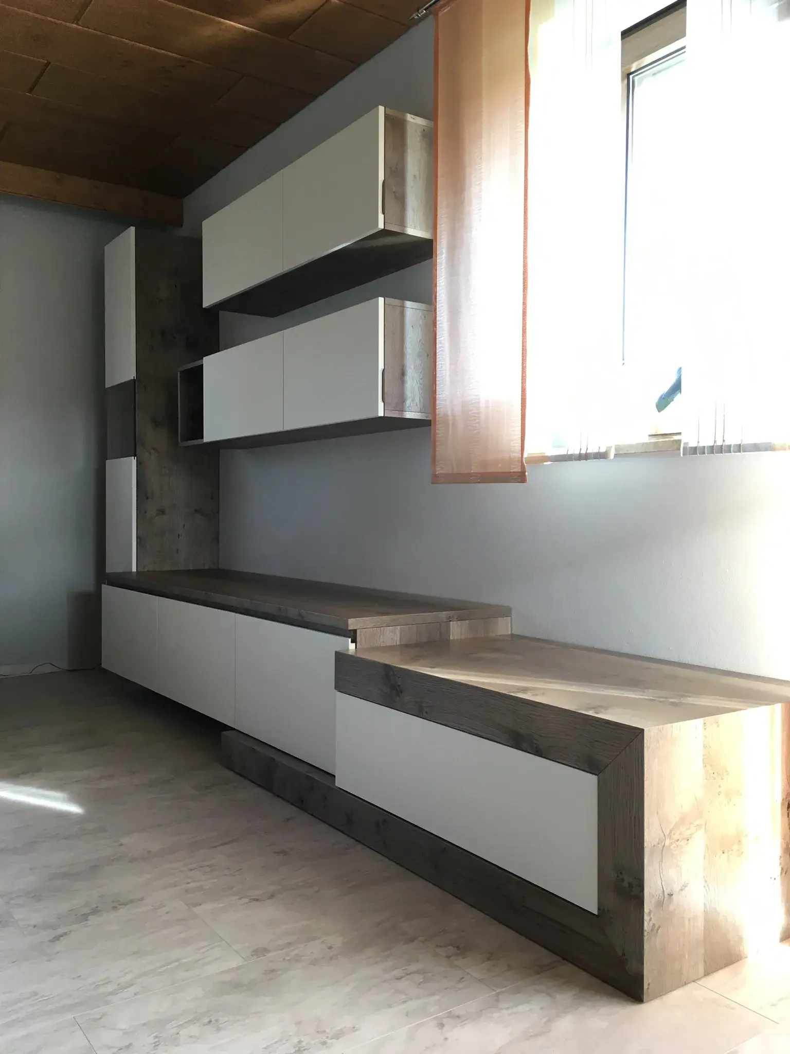 Moderne, minimalistische Einbauschränke mit weißen Fronten und Holzdetails an einer Wand.